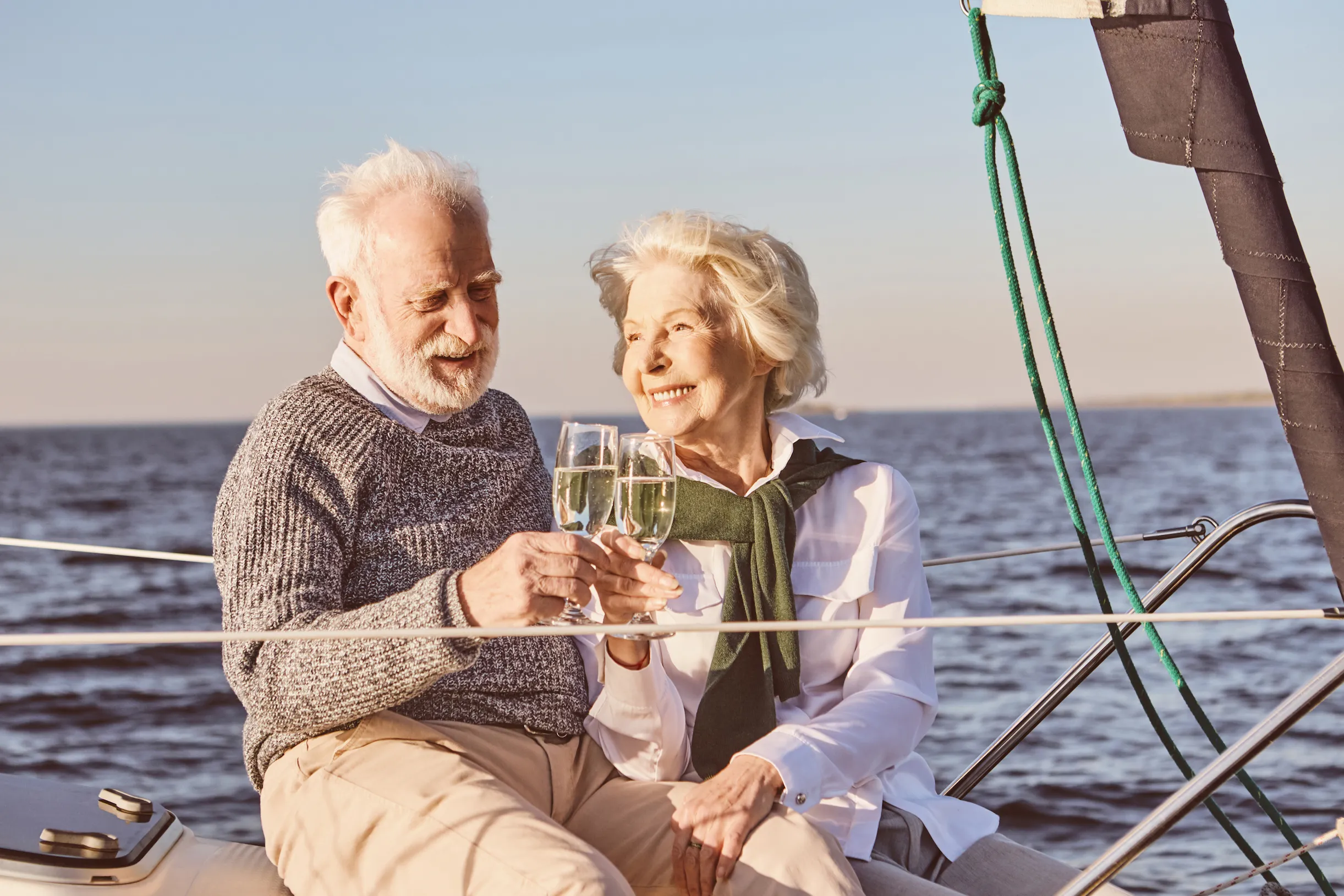 A retired couple enjoying champagne on their boat.