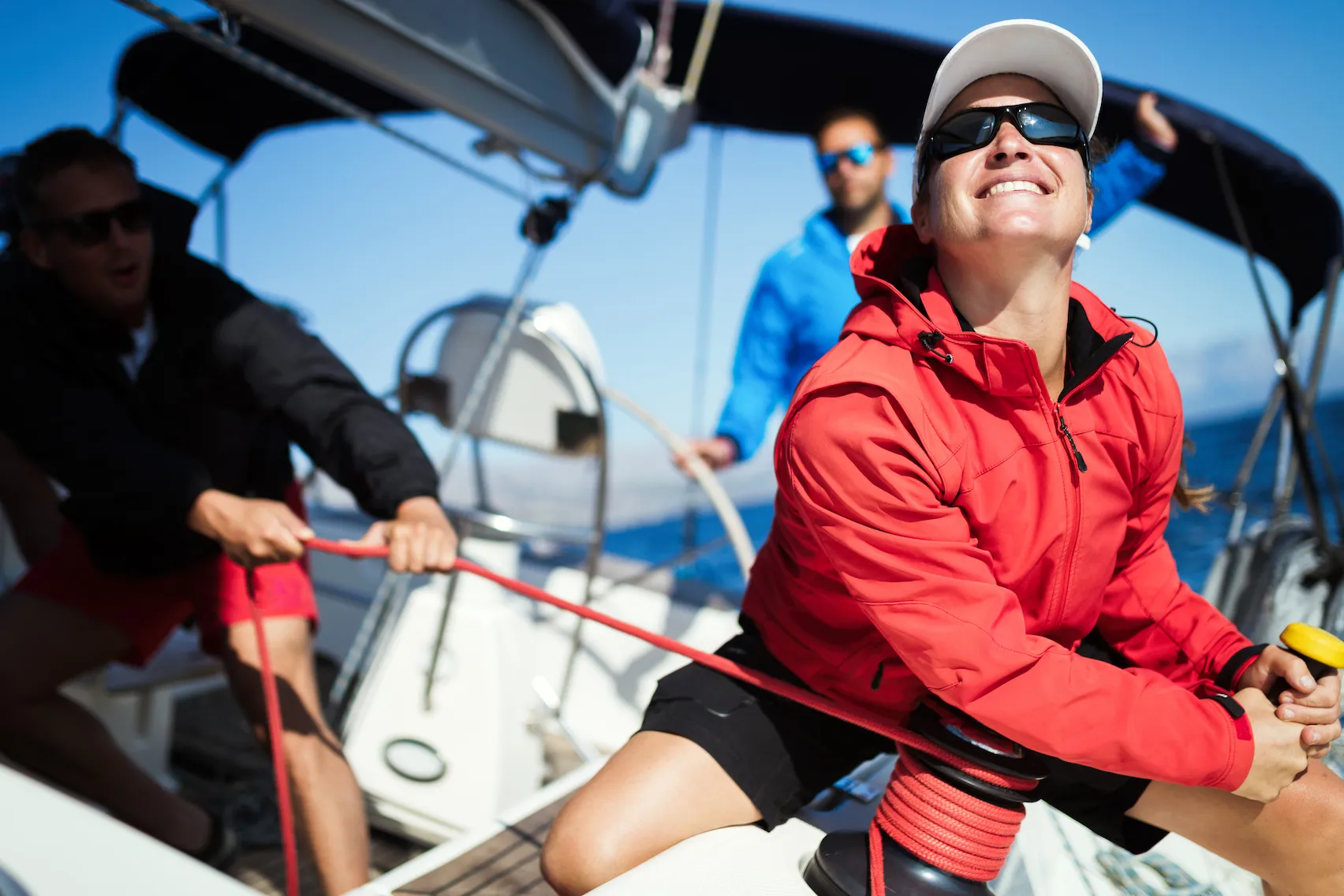 A woman handling the ropes of a sail boat.